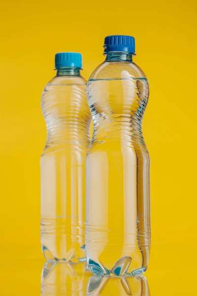 Botella de plástico llena de bebida sobre un fondo amarillo brillante — Foto de Stock