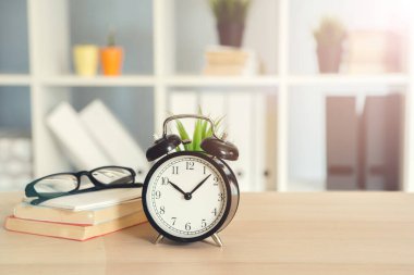 Çalar saat ve ofis kırtasiye nesneleri ahşap masada yakın