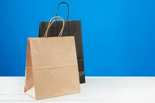 Arreglo de bolsas de compras sobre fondo azul —  Fotos de Stock