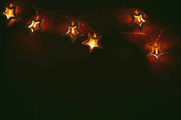 Hermosa luz bokeh de guirnalda en forma de estrella en la oscuridad —  Fotos de Stock