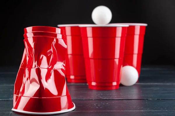 Mesa de madera con copas rojas y bola para pong de cerveza — Foto de Stock