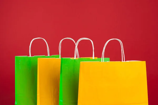 Arranjo de sacos de compras no fundo vermelho — Fotografia de Stock