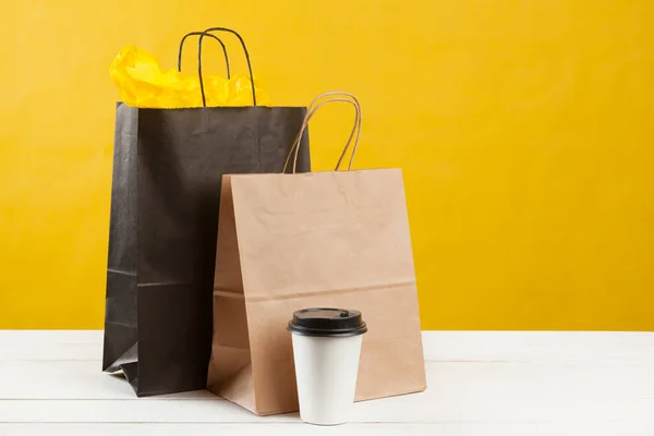 Arranjo de sacos de compras no fundo amarelo brilhante — Fotografia de Stock