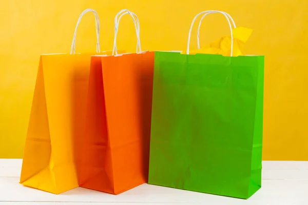 Arreglo de bolsas de compras sobre fondo amarillo brillante — Foto de Stock