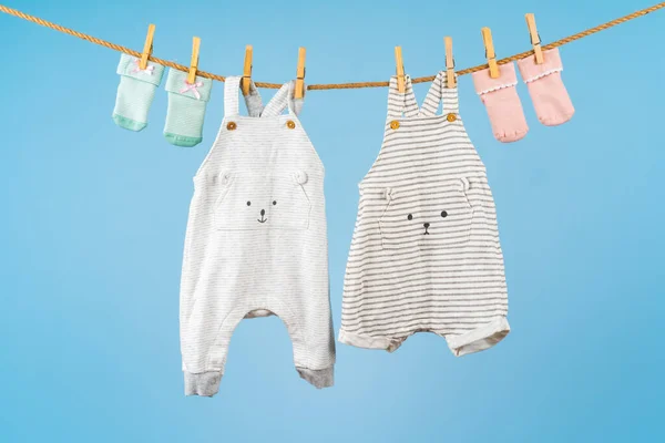 Niedliche Kleinkind bunte Kleidung hängen an einem Seil — Stockfoto
