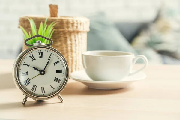 木製の背景に古典的なヴィンテージ目覚まし時計とコーヒーカップ — ストック写真