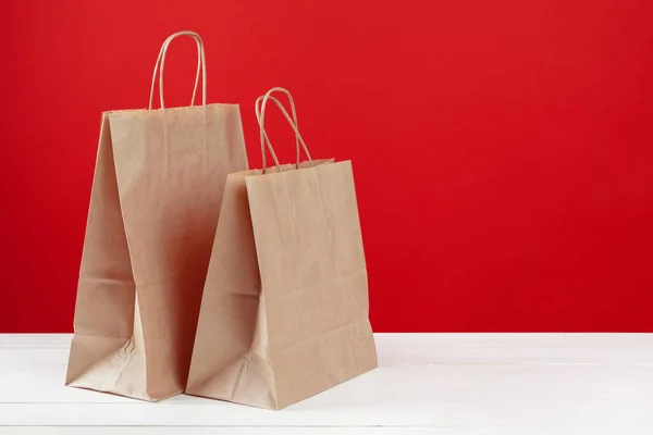 Arranjo de sacos de compras no fundo vermelho — Fotografia de Stock