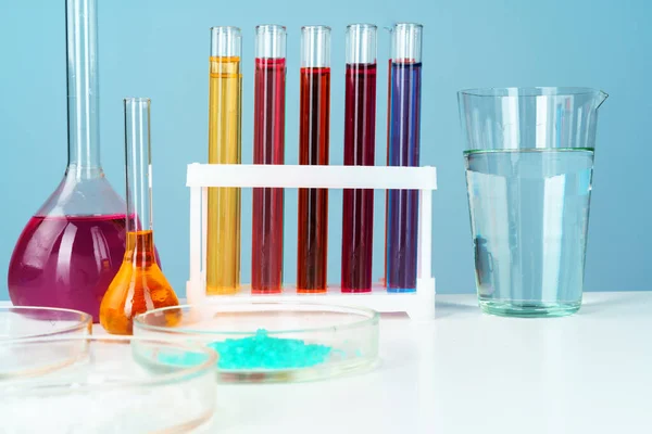 Chemiczne laboratoryjne szkło z różnymi barwnymi płynami na stole — Zdjęcie stockowe