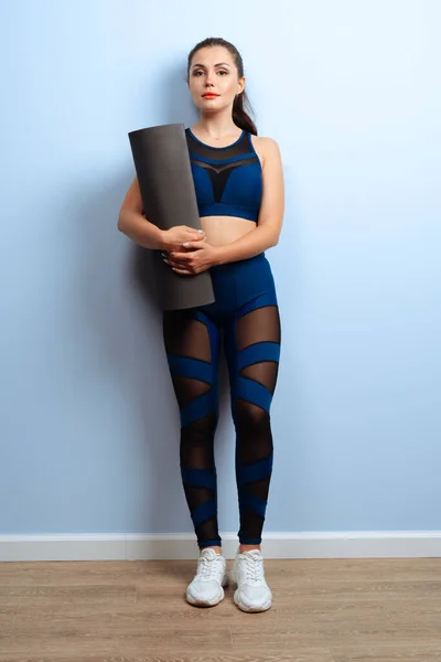 Jong slank vrouw holding yoga fitness mat in haar handen — Stockfoto