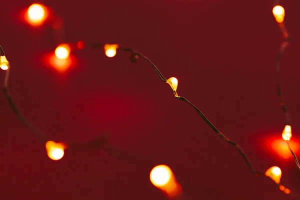 Fondo rojo con luces iluminadas de guirnalda — Foto de Stock