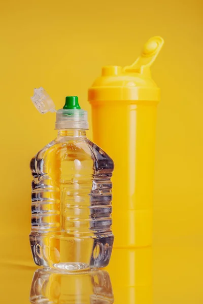 Botella de plástico de agua mineral sobre un fondo amarillo brillante — Foto de Stock