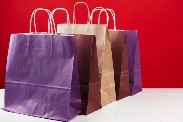 Varias bolsas de compras con espacio de copia sobre fondo rojo — Foto de Stock