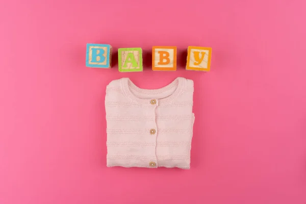 Baby kleding op roze achtergrond bovenaanzicht — Stockfoto