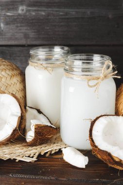 Hindistan cevizi sütü cam kavanoz ahşap arka plan üzerinde yakın