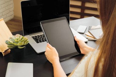 Ofiste ki masada oturan dijital tablet kullanan kadın