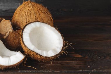 Koyu ahşap arka plan üzerinde Çatlak hindistan cevizi parçaları