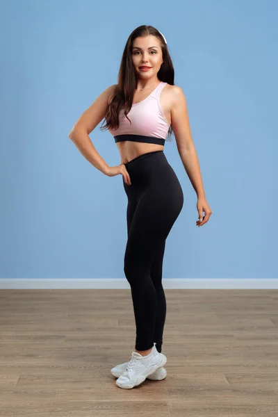 Portret van een jonge fitnessvrouw in sportkleding poserend in studio — Stockfoto