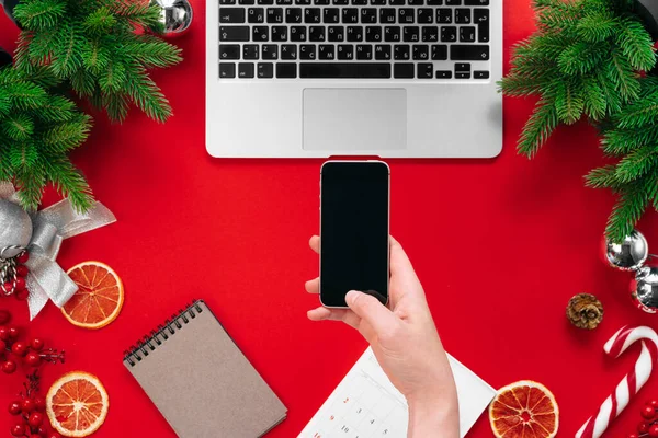 Laptop z gałęzi futra i ozdoby świąteczne na czerwonym tle widok z góry — Zdjęcie stockowe