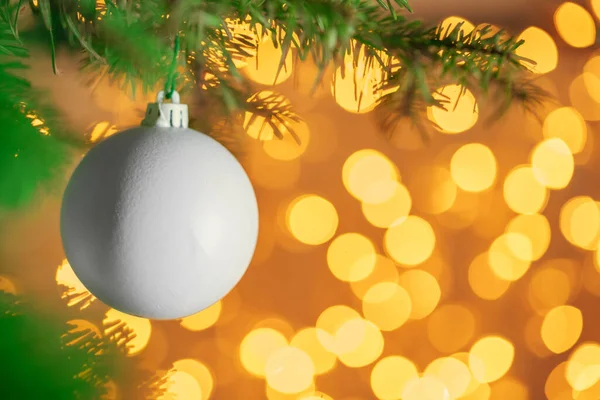 Noel süslemeleri Noel ışıklarına karşı bir köknar dalında asılı. — Stok fotoğraf