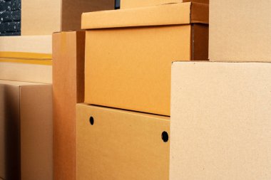 Kara tuğla duvara karşı boş odada yığınla karton kutu.