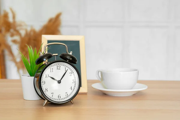 Классический винтажный будильник и чашка кофе на деревянном фоне — стоковое фото