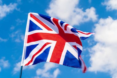 Mavi gökyüzünde rüzgarsal sallanan Birleşik Krallık Bayrağı