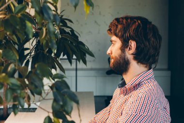 Modern ofiste çalışan sakallı genç iş adamı.