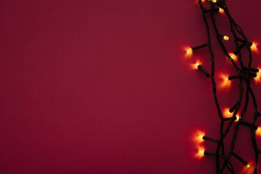 Parlak pembe arka planda aydınlatılmış çelenk ışıkları