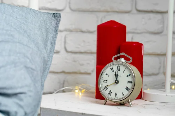 Relógio de alarme vintage de metal em pé na mesa de cabeceira perto da cama close-up — Fotografia de Stock