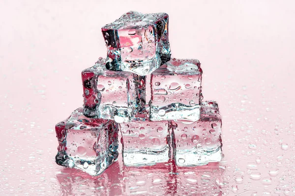 Kostki lodu na różowym tle — Zdjęcie stockowe