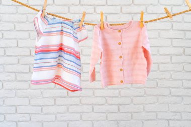 Kuruması için ipe iğnelenmiş bebek kıyafetlerinin yıkanması.