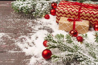 Noel hediyesi, karla kaplanmış ahşap masa.