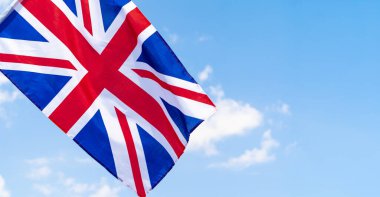 Mavi gökyüzünde rüzgarsal sallanan Birleşik Krallık Bayrağı