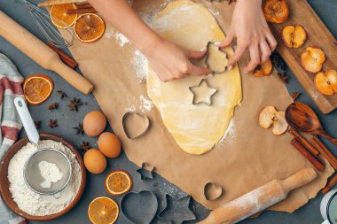 Kadın eli evde taze hamurdan kurabiye yapıyor.