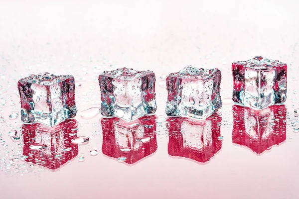 Cubos de hielo sobre fondo rosa —  Fotos de Stock