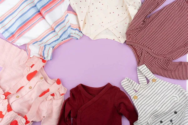 Vestiti bambina su sfondo pastello lilla — Foto Stock