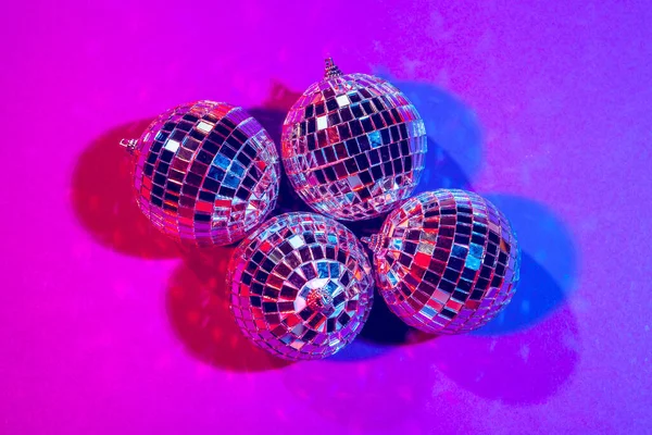 Блискучі маленькі диско-кулі блискучі в красивому фіолетовому світлі. концепція вечірки дискотека — стокове фото