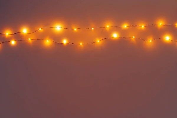 Guirnalda eléctrica dorada brillante sobre un fondo gris —  Fotos de Stock