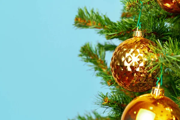 Árvore de Natal com bugigangas douradas fechar no fundo azul — Fotografia de Stock