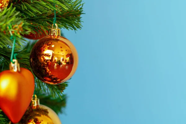 Χριστουγεννιάτικο δέντρο με χρυσά στολίδια κοντά σε μπλε φόντο — Φωτογραφία Αρχείου
