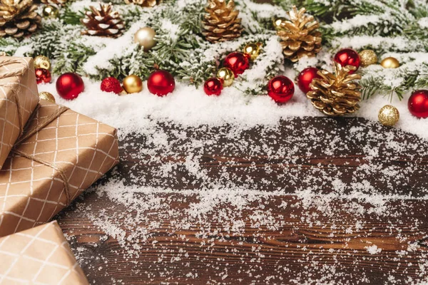 Presente festivo com arco de perto no fundo de madeira com neve — Fotografia de Stock