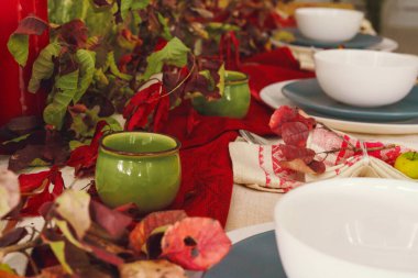 Balkabağı ve kurumuş dallarla süslü bir sonbahar sofrası.