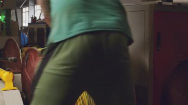 Tanınmayan işçiler kablo üretiminde kabloyla makarayı sarıyor.