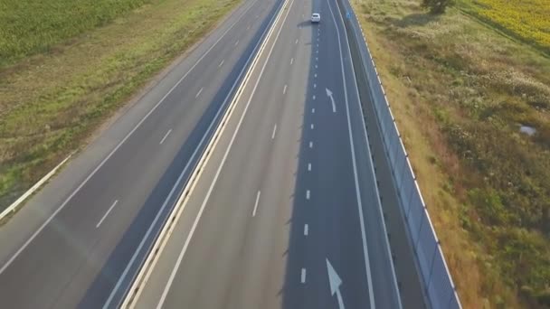 Drone vista aérea por encima de la carretera en el campo con coches en movimiento — Vídeo de stock