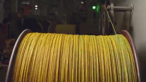 Draaiende haspel met gele kabel in kabelproductie close-up — Stockvideo