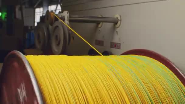 केबल उत्पादन बंद-अप में पीले केबल के साथ स्पिनिंग रील — स्टॉक वीडियो