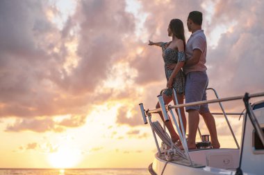 Güzel bir çift yattan gün batımını seyrediyor.