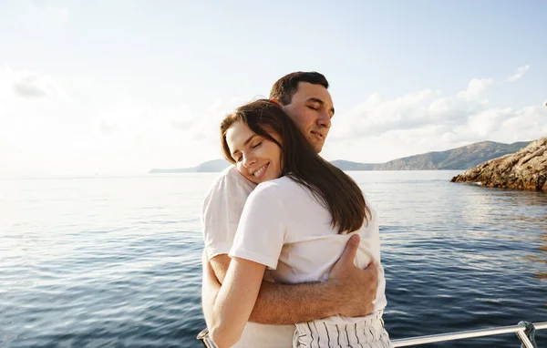 若いです愛情のあるカップル抱擁立っている上にザヨットで海 — ストック写真