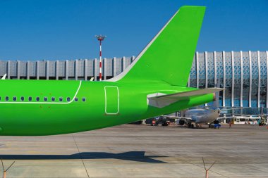 Güneşli bir günde havaalanında yeşil yolcu uçağı