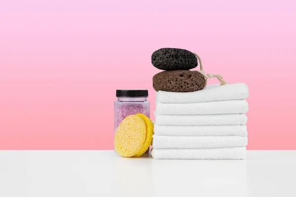 Ręczniki kąpielowe i sól spa na białym stole — Zdjęcie stockowe